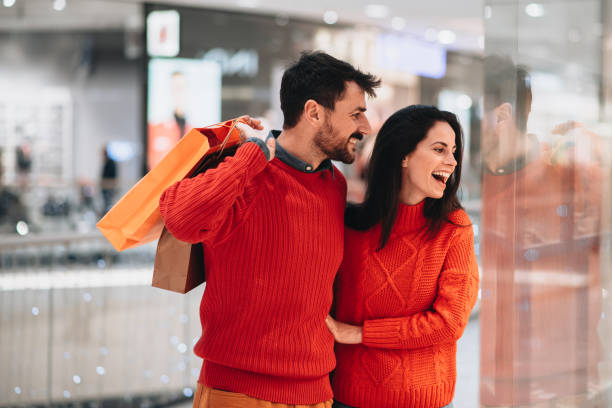 Happy attractive loving couple enjoy shopping together stock photo