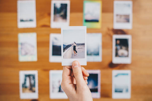 istock Woman holding instant photos from a trip 1448809938
