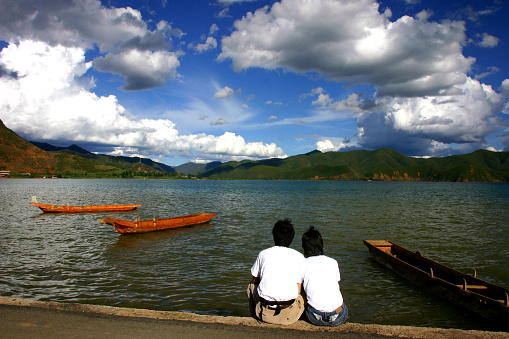 A sunny summer day at Lugu Lake, a couple of young people looking at the cloud. Photo in 06/22/2007, Lugu Lake, Yunnan