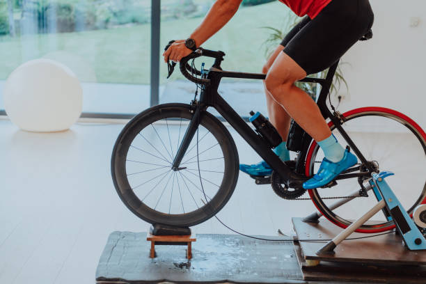 istock A man riding a triathlon bike on a machine simulation in a modern living room. Training during pandemic conditions. 1448811051