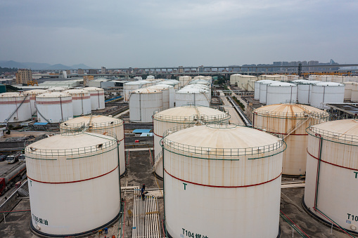 Oil storage tanks under cloudy sky