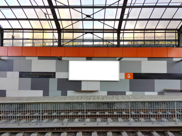 istock An empty white billboard hangs at an empty tram stop with a scrap for text. Mockup for advertising 1448818096