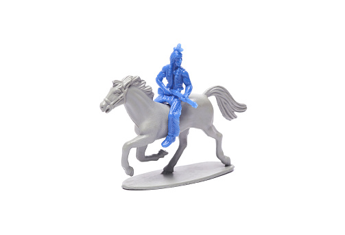 Plastic toy figurine of native american warrior with a gun on horse isolated on white background
