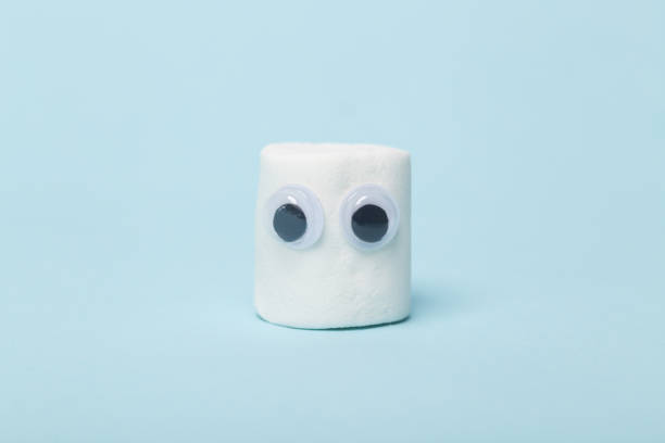 istock Cute marshmallow with eyes on a blue background 1448819264