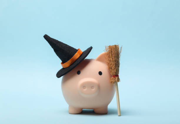 Halloween Piggy bank witch hat and a broom on a blue background stock photo