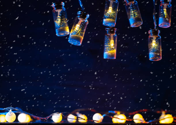 istock Christmas garland background, glowing light bulbs on a blue background, copy space, falling snow 1448827087