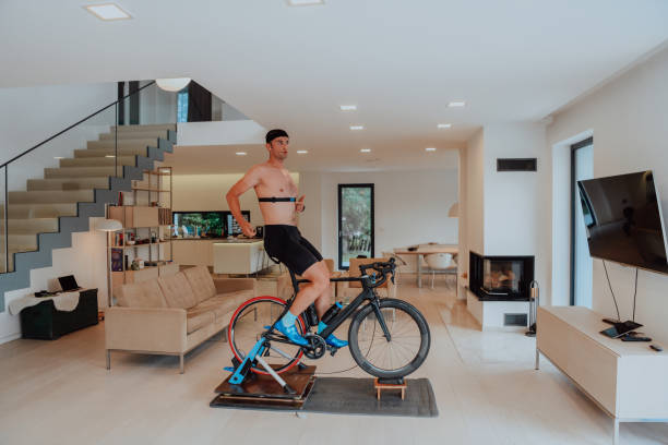 istock A man riding a triathlon bike on a machine simulation in a modern living room. Training during pandemic conditions. 1448830507
