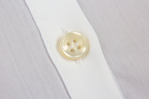 sewn button to shirt close-up
