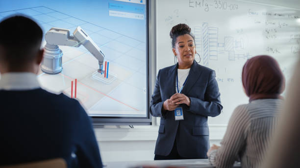 istock Black Lecturer Points at 3D Robotic Arm Moves and Discusses it With Students in Contemporary Auditorium. Formation of Highly Intellectual Youth in Modern Educational Environment Concept. 1448837137