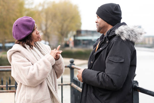 istock A deaf couple portrait using sign language beside River Thames. 1448838090