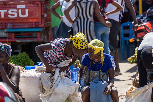 Pedernales, Dominican Republic, 22 august 2022. Two haitian ladies with yellow bandana hats chatting away while buying and selling.