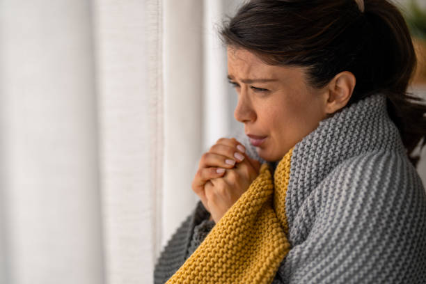 istock Young woman shivering at home. 1448840333
