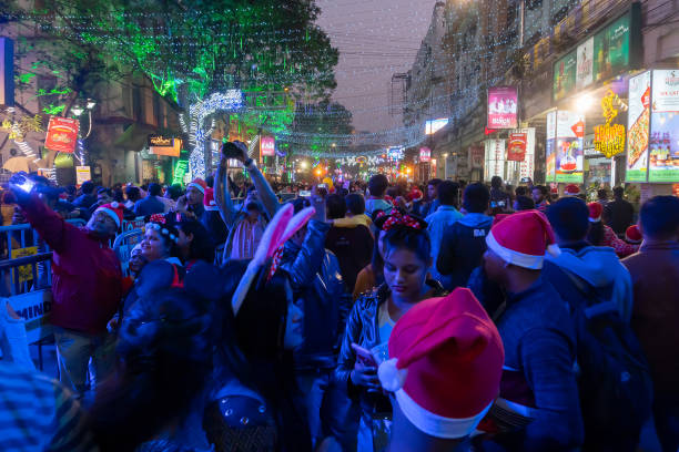 Christmas celebration by public at illuminated and decorated park street with lights and year end festive mood. stock photo