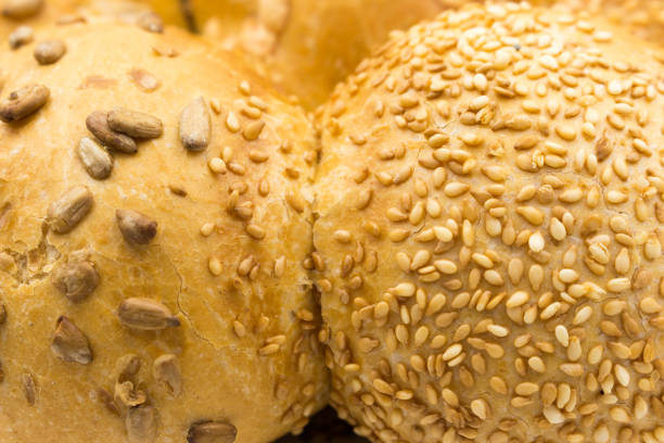 Fresh fluffy buns sprinkled with sunflower and sesame seeds, Close-up.