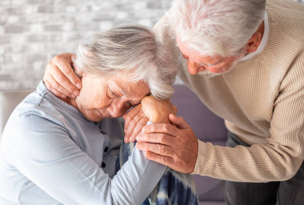 Senior man comforting his depressed illness wife, unhappy elderly woman at home. Ourmindsmatter Senior man comforting his depressed illness wife, unhappy elderly woman at home. Ourmindsmatter dementia stock pictures, royalty-free photos & images