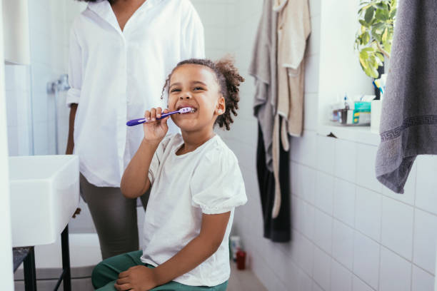 Girl Brushing Her Teeth Cute little Cuban girl brushing her teeth in the morning. brushing teeth stock pictures, royalty-free photos & images