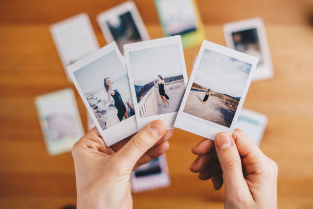 istock Woman holding instant photos from a trip 1448852228