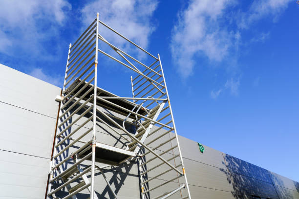 istock Modern metal scaffolding next to a new building gray sandwich panel wall, blue sky background 1448858434