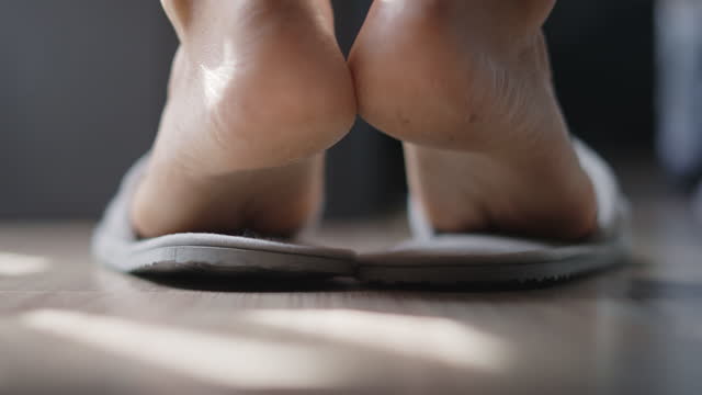 Unrecognizable man putting on slippers after getting out of bed,Slow motion