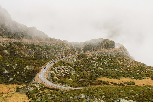 Road with cars, over the mountains of Serra da Estrela in Portugal. Rainy and foggy day.
