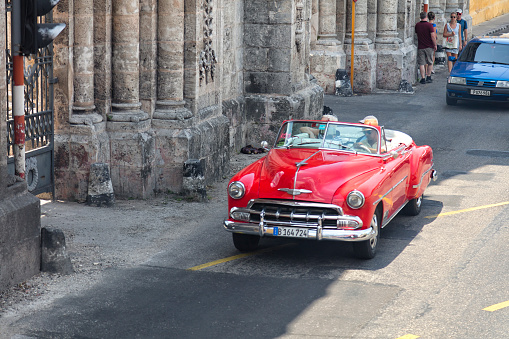 Havana, Сuba - April 21, 2018: Vintage American car driving through the street in Havana Vieja, Cuba.