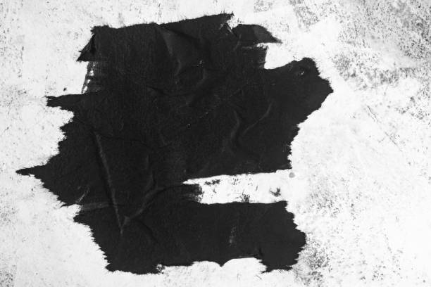istock A piece of black paper on a concrete wall. 1448864845