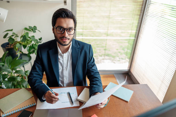 istock Handsome businessman in suit working with documents from home office and looking at camera 1448864982