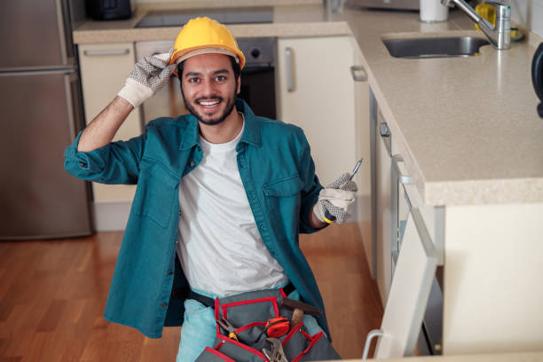 istock Smiling professional worker in uniform is assembling furniture on kitchen. Repair concept 1448865651