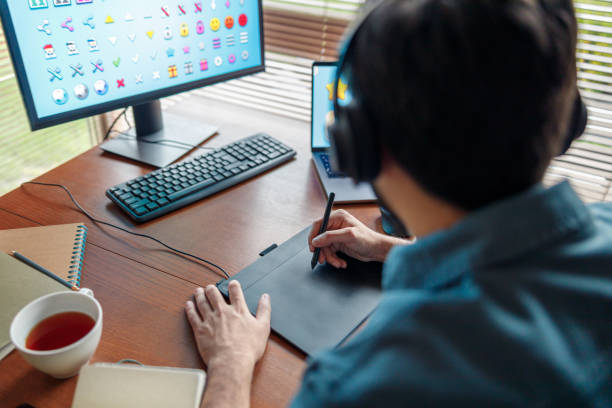 istock Male designer works in home office drawing on graphic tablet. Freelancer working on project 1448866151