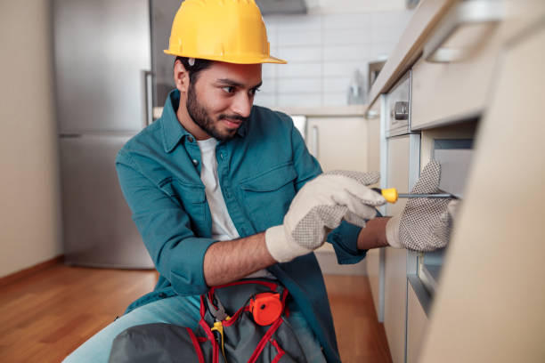 istock Smiling professional worker in uniform is assembling furniture on kitchen. Repair concept 1448866188