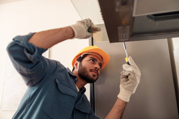 tuttofare in uniforme riparando l'estrattore da cucina, sostituendo il filtro nella cappa. concetto di manutenzione - exhaust fan foto e immagini stock