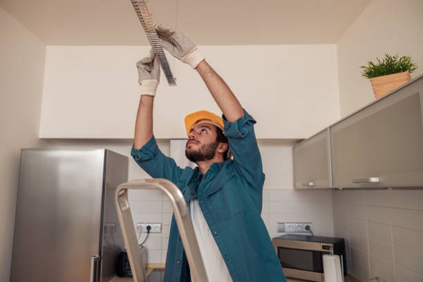 Professional electrician worker in uniform is installing electric lamps light in kitchen Electrician worker is installing electric lamps light in kitchen. Construction decoration concept handyman stock pictures, royalty-free photos & images