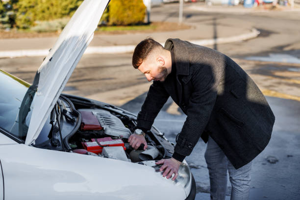 istock A young handsome man had a car accident on the road and trying to fix the problem. 1448870291