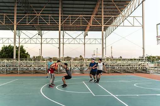 Young friends having a basketball match at a sports court