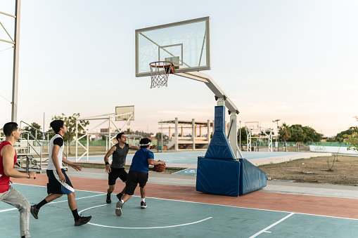 Young friends having a basketball match at a sports court