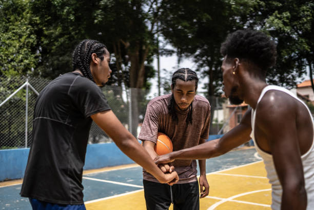 istock Young men stacking hands at a sport court 1448876637