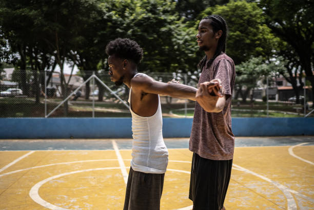 istock Young men stretching at a sport court 1448876783