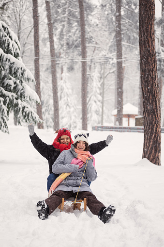 Beautiful teenage girls sledding together on a cold winter day