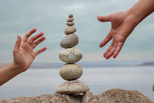 pile of stones on the beach. Top view of various stones on the beach. two human hands face to face. combat, war and strategy.