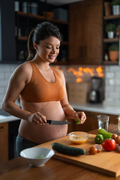 istock Pregnant woman preparing eggs for breakfast 1448879000