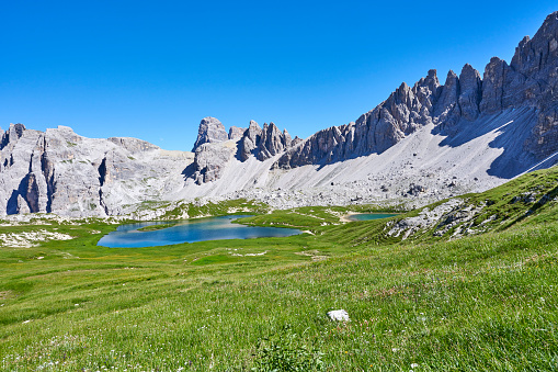 Shot taken on the Sella massif, which is placed between the Alta Badia and the Val Gardena (Gröden) Valleys. In this photo the famous Pisciadù Lake is in the foreground and reflections of the Sella Massif peaks around it are visible.