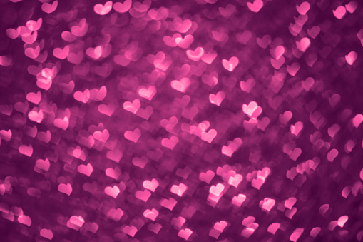 DSLR photo - defocused bokeh with a heart shape, toned in purple color. Space for copy. Can be used as a Christmas background or other holiday background. It's a REAL bokeh photo, not an illustration or computer filter.