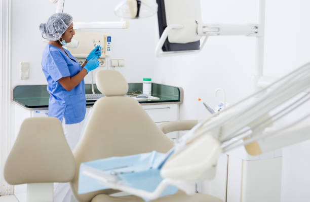 istock Female dentist checking and arranging tools in dental office 1448891071