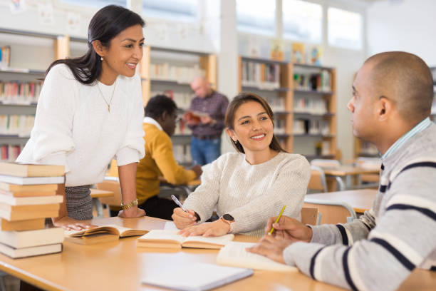 istock Group of positive adult hispanic students communicating in library 1448891420