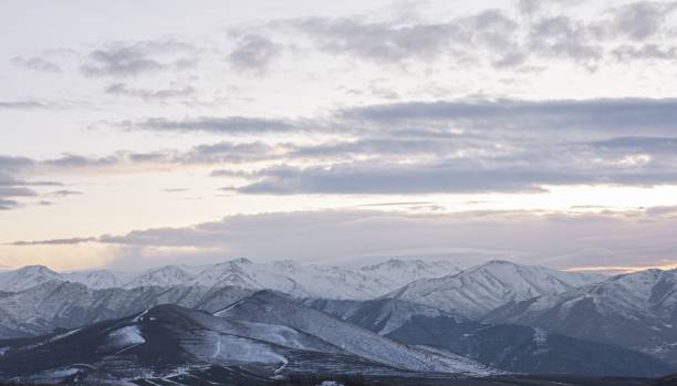 istock Drone shot of snowy mountain layers under cloudy sky at sunset 1448903493