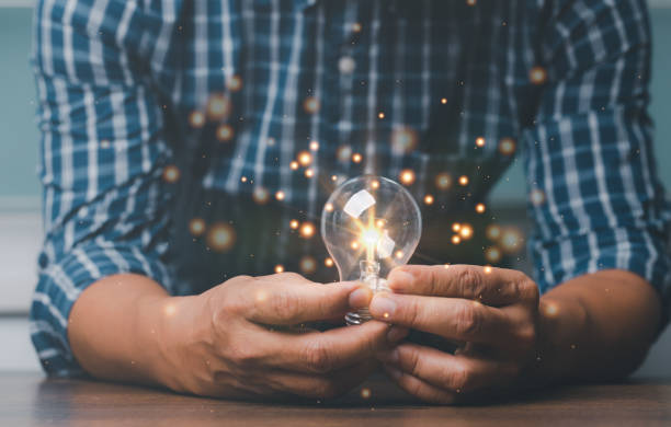 istock Man hand holding illuminated light bulb, concept creativity with bulbs shine glitter ideas. 1448909026