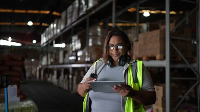 Portrait of a woman using digital tablet in a warehouse
