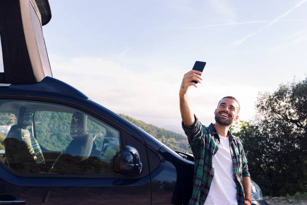 istock man taking a selfie leaning on his camper van 1448912539