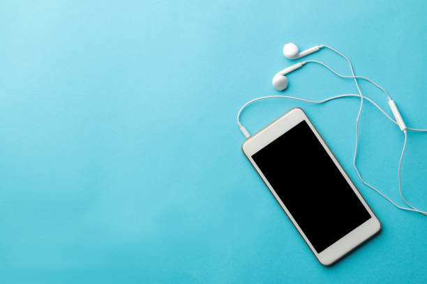 istock Smartphone. White phone and headphones on a bright light blue background. top view. space for text 1448912596