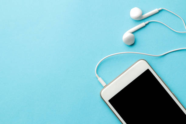 istock Smartphone. White phone and headphones on a bright light blue background. top view. space for text 1448912604